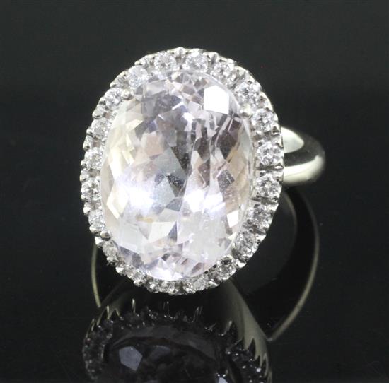 An 18ct white gold, kunzite and diamond oval cluster dress ring, size L.